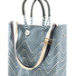 Blue and white chevron woven bucket bag made from recycled plastics featuring navy blue leather handles and a silver Coba medallion with option woven strap added