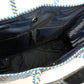 Inside navy blue lining featuring 2 pockets and magnetic closure of blue and white chevron woven bucket bag made from recycled plastics featuring navy blue leather handles and tassel detail