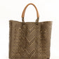 Brown and tan chevron woven bucket bag made from recycled plastics and featuring a tan leather handles