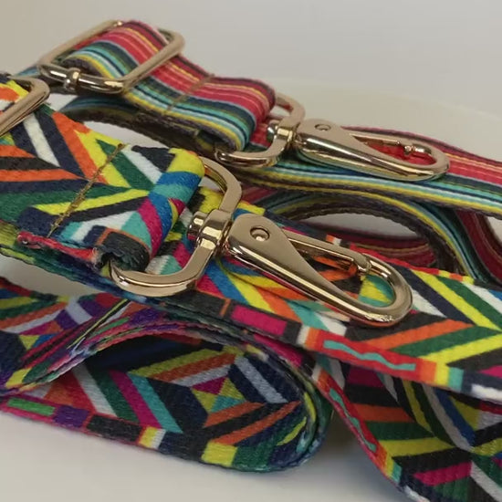 Two multi color purse straps in a row