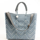Herringbone pattern purse strap clipped to blue and white chevron tote bag