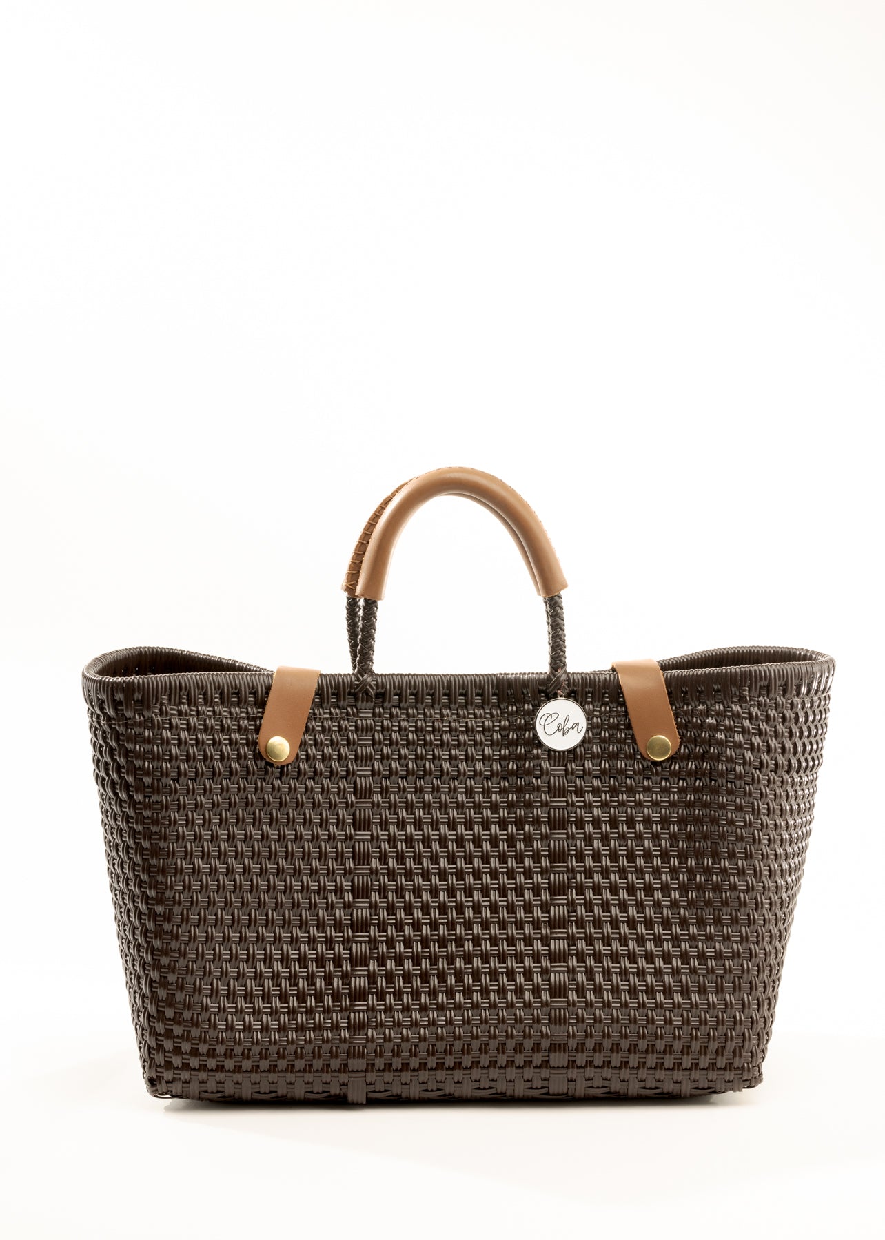 Brown woven recycled bucket handbag with brown leather handles and closure straps and a silver COBA logo medallion