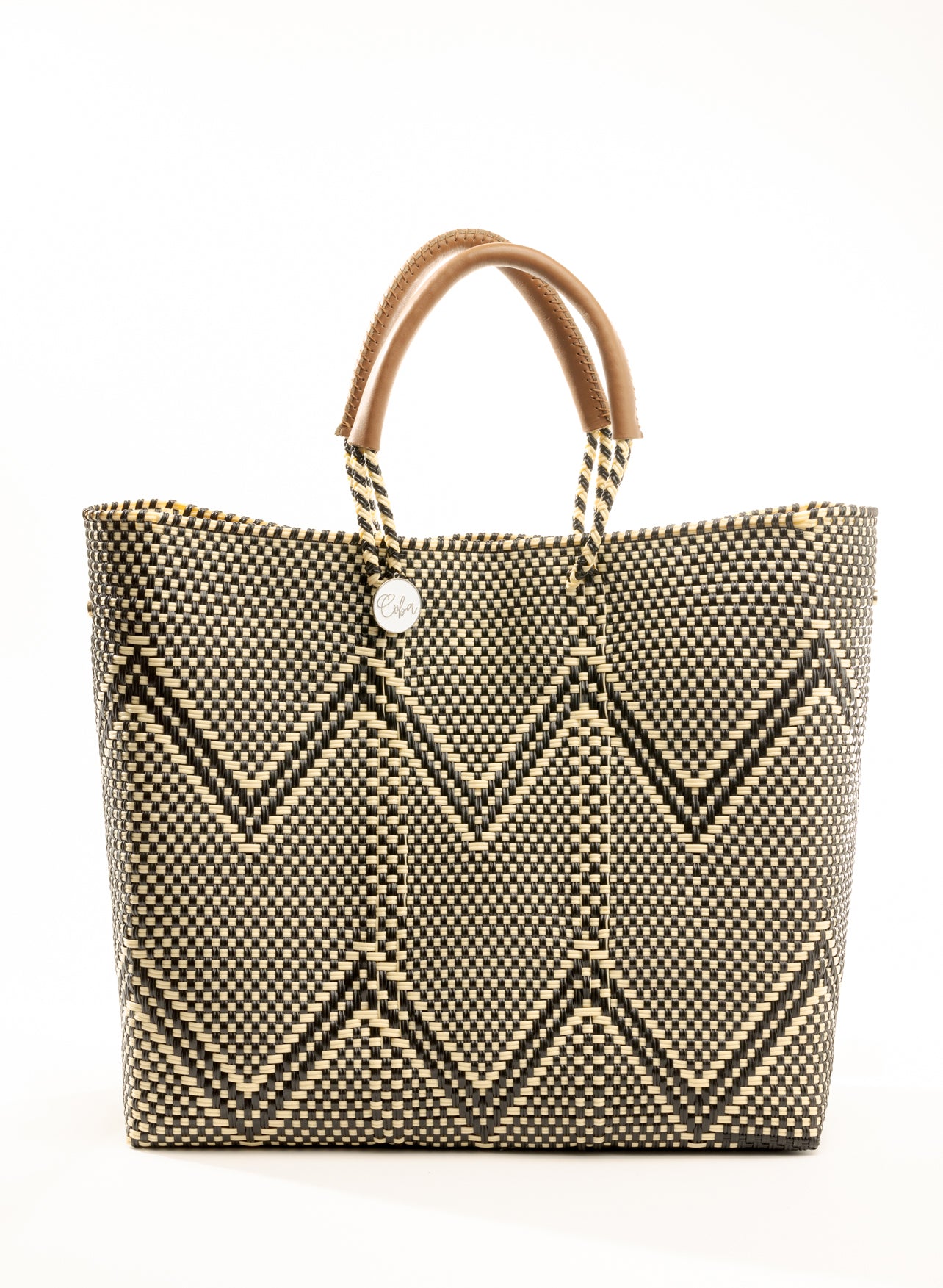 Tan, cream, and brown chevron tote bag made from recycled plastics featuring a tan leather handle and silver Coba medallion detail