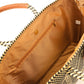 Inside tan lining featuring a zipper pocket and magnetic closure of tan, cream, and brown chevron tote bag made from recycled plastics