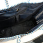 Inside navy blue lining featuring 2 pockets and magnetic closure of blue and white chevron woven bucket bag made from recycled plastics featuring navy blue leather handles and tassel detail