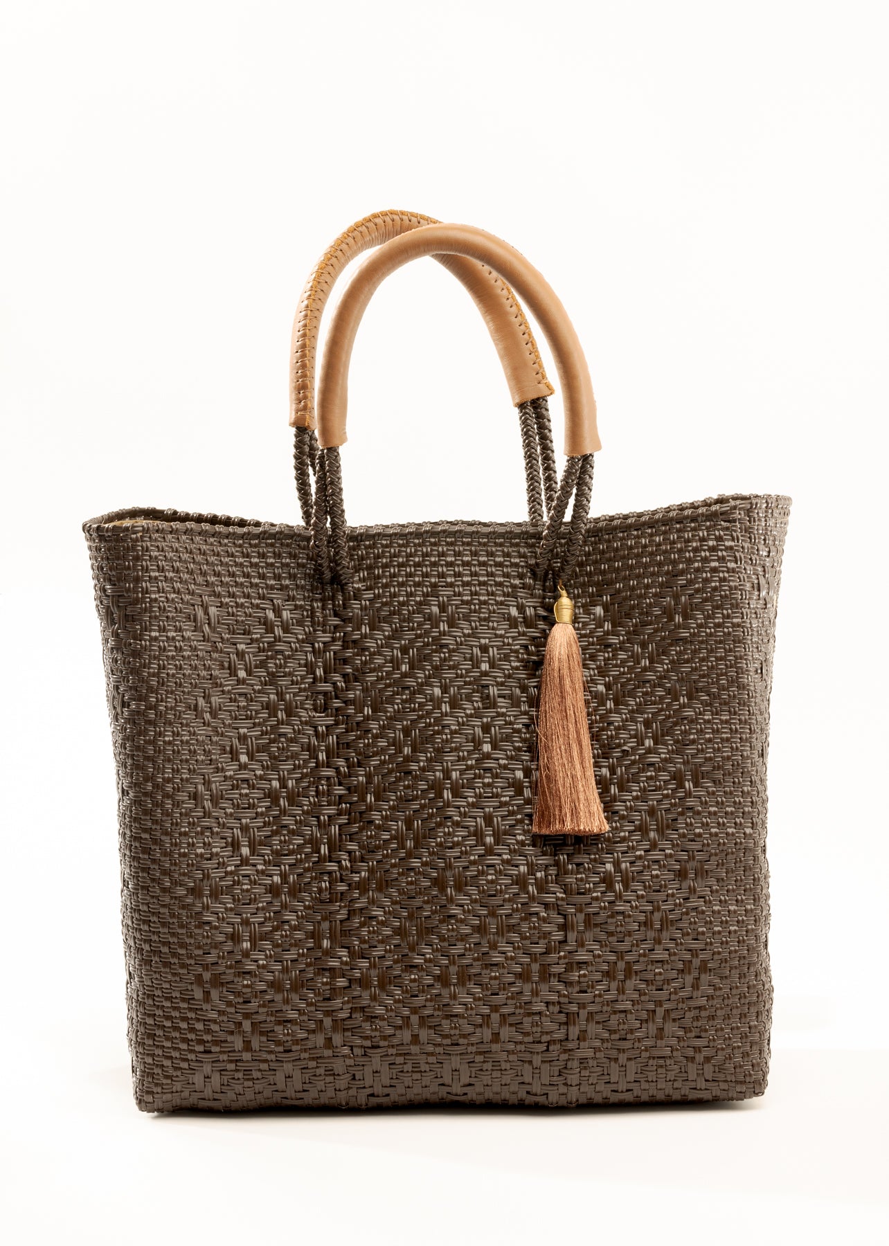 Brown and tan woven handbag made from recycled plastics featuring tan leather handles and tassel detail