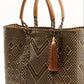 Side angle of brown and tan chevron woven bucket bag made from recycled plastics and featuring a tan leather handle and tassel detail