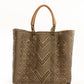 Brown and tan chevron woven bucket bag made from recycled plastics and featuring a tan leather handles