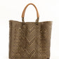 Brown and tan chevron woven bucket bag made from recycled plastics and featuring a tan leather handles