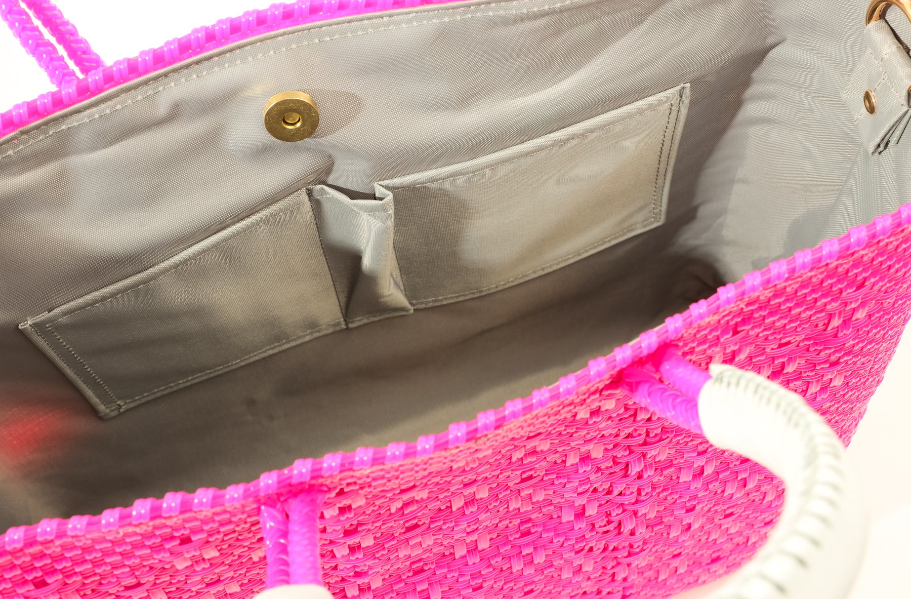 Light gray lining of hot pink woven bucket bag with two pockets and magnetic closure