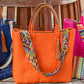 Colorful geometric pattern purse strap on orange woven handbag